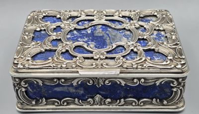 a silver and lapis box with a blue stone in the center