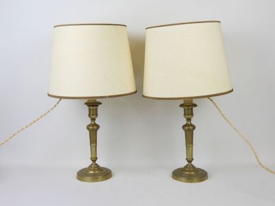 pair of brass table lamps with white lampshads on them