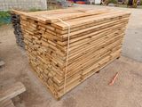 un tas de bois posé par terre devant un bâtiment