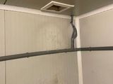 a toilet in the corner of a bathroom with a shower head on the wall
