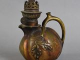 une théière en bronze surmontée d'une couronne