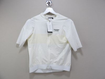 the white shirt is hanging on a hanger on the wall