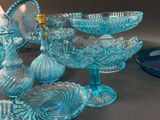 many blue glass dishes and glasses on the table