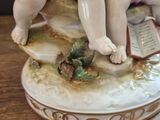a figurine of a boy and a girl sitting on a book