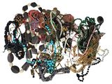 a pile of assorted necklaces and bracelets on a white surface