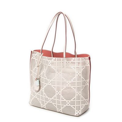 a white tote bag with holes and a red handle