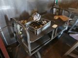 a metal cart with a bunch of items on it