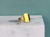 a close up of a gold plated ring on a marble block