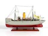 une maquette de bateau posée sur un socle, sur une surface blanche