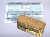 un lingot d'or posé à côté d'un ticket de caisse sur une table