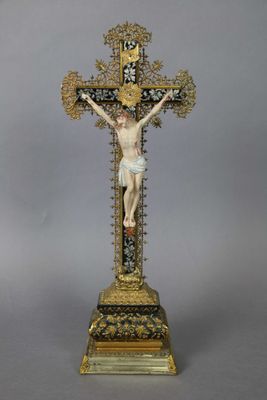 a statue of jesus on the cross with a cross in the background
