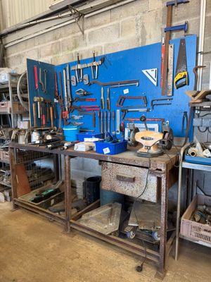 une photo d'un établi dans un garage avec des outils dessus