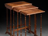 un ensemble de trois tables gigognes en noyer avec des pieds tournés