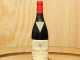une bouteille de vin posée sur un tonneau en bois