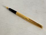 a close up of a pen on a table with a white background