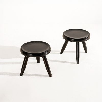 deux petits tabourets noirs posés sur une surface blanche