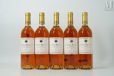 four bottles of wine are lined up on a table