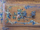 a close up of a wooden cabinet with flowers on it