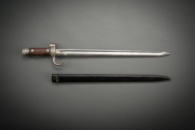 two swords and a knife on a gray background