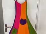 a colorful dress hanging on a hanger in front of a door