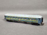a blue and yellow train car sitting on a gray surface