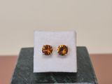 a pair of earrings sitting on top of a marble block