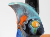 a blue and orange vase with a bird on top of it