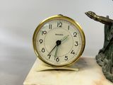a small clock sitting on top of a marble block