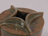 a brown vase that has a leaf design on it