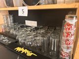 many glasses and cans on the shelf in the store