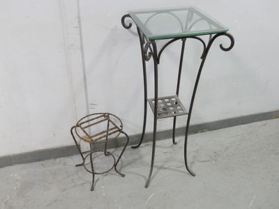 a small glass table with a metal stand next to it