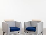 deux chaises avec des coussins bleus dans une pièce blanche aux murs blancs