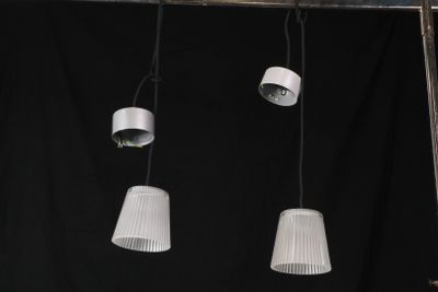trois lampes blanches suspendues au plafond sur fond noir