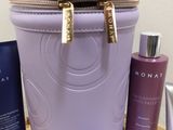 a purple bag sitting on top of a table next to a bottle of lotion