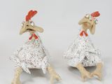 three figurines of chickens that are sitting on a table