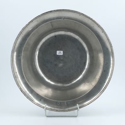 a silver plate on a metal stand on a white surface