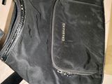 un sac noir muni d'une fermeture éclair, posé par terre