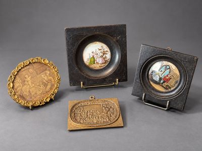 three small pieces of art on display on a gray surface