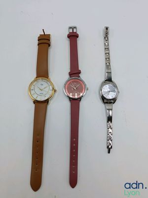 trois montres différentes posées les unes à côté des autres sur une surface blanche