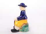 a figurine of a man sitting on a rock