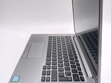 a silver laptop with a blue sticker on the keyboard