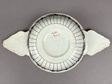 a white bowl with a black and red design on it