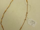 collier plaqué or avec un fil torsadé et une plaque sur un fond blanc