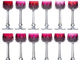 twelve red wine glasses lined up in a row on a white background
