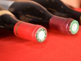several bottles of wine are lined up on a red table