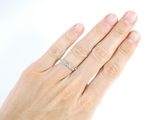 a woman ' s hand with a diamond ring on it