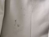 the jacket is white and has a small hole in it