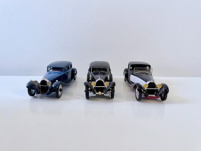 trois petites voitures posées sur une table