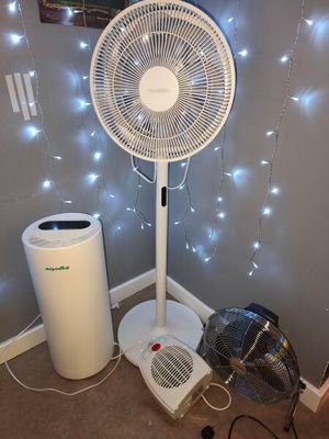a fan that is sitting on the floor next to a trash can