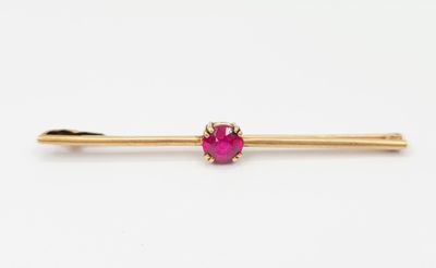un lingot d'or orné d'une pierre rose